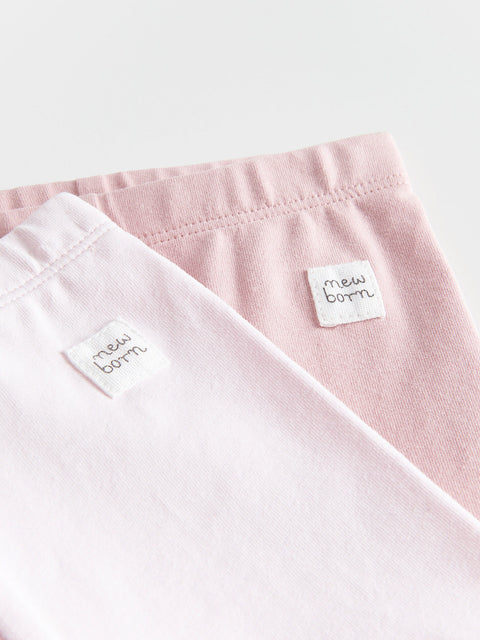 Two pink baby blankets with 'new born' labels on a white background