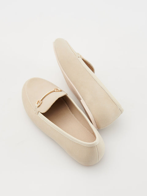 Beige loafers with a gold buckle on a light gray background