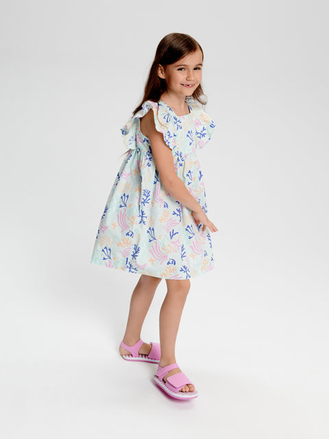 Young girl wearing a floral dress on a white background