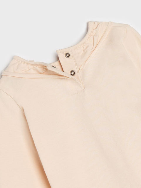 Close-up of a beige shirt with buttons on a white background