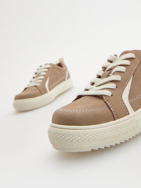 Pair of brown sneakers with white laces on a light gray background