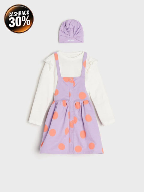 Children's outfit with a purple dress with orange polka dots, white shirt, and purple headband on a light gray background.