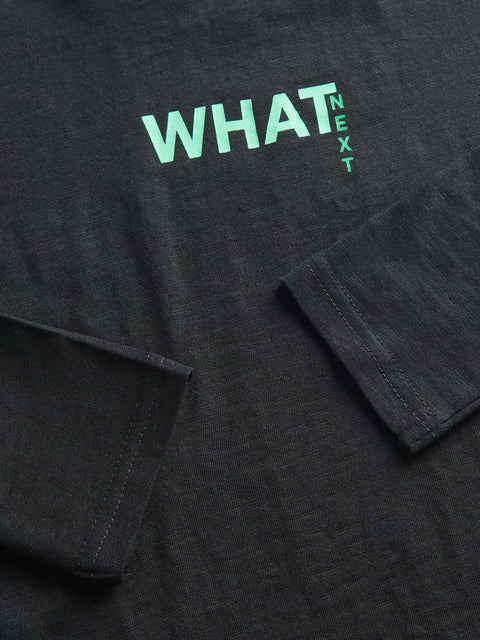 Black shirt with 'WHAT NEXT' text in green on a dark background