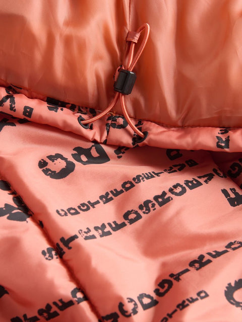 Close-up of a pink jacket with black text and a drawstring on a matching pink background.