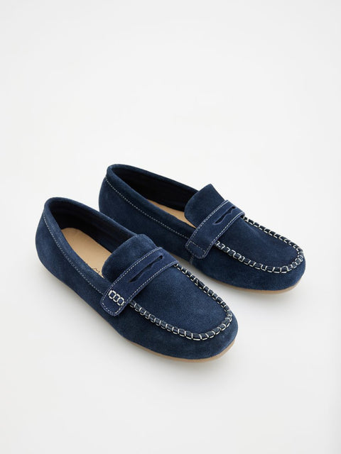 Pair of navy blue loafers with chain details on a light gray background