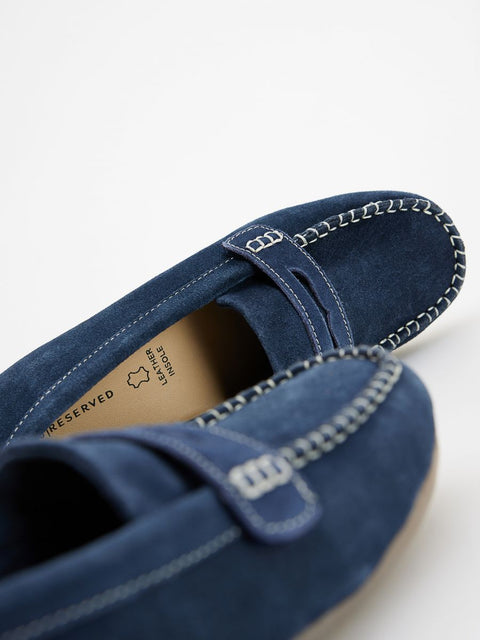 Blue loafers with a close-up of the sole on a white background