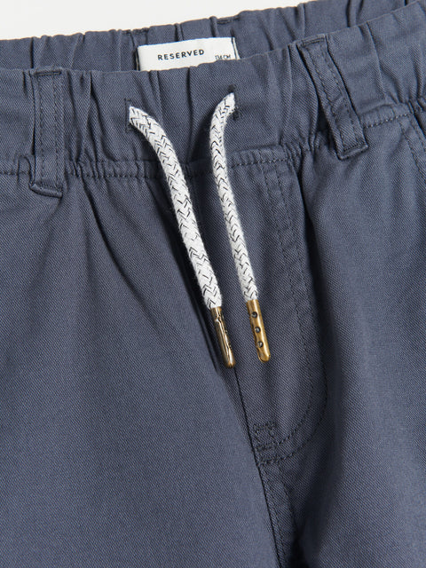 Navy blue shorts with a drawstring and brand label on a white background