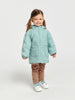 Child wearing a light blue quilted jacket on a white background