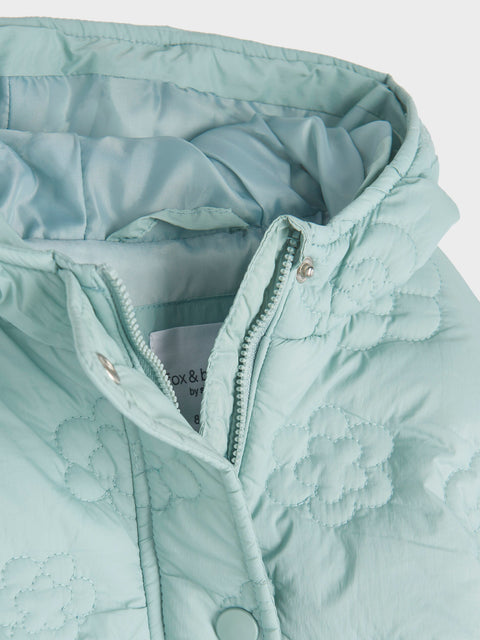 Close-up of a light blue jacket with a zipper on a white background