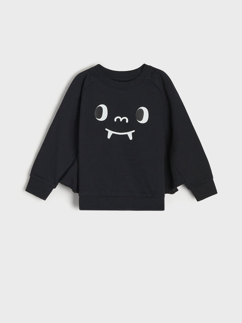 Black sweatshirt with a white face design on a light gray background