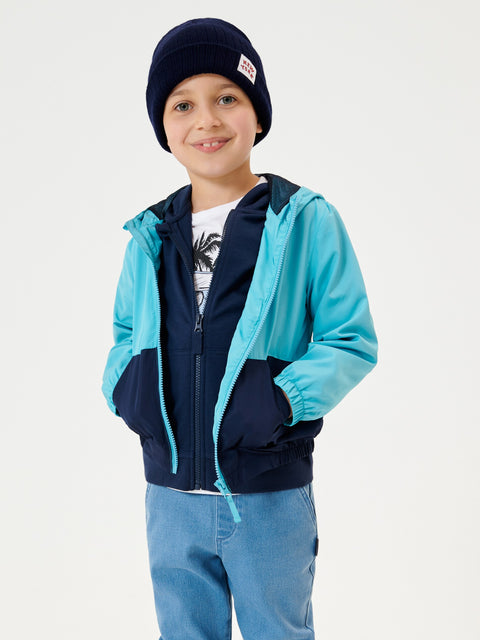 Child wearing a blue and navy jacket with a white background