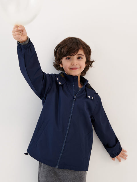 Child wearing a navy blue jacket against a white background