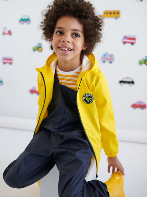 Child wearing a yellow raincoat with a car-themed background