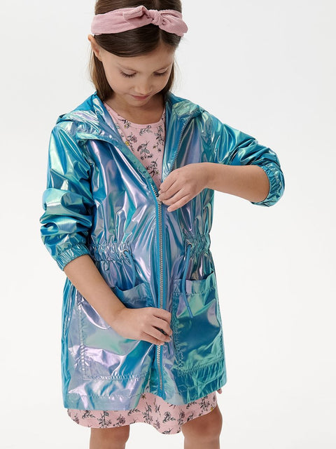 Child wearing a shiny blue raincoat over a floral dress on a white background