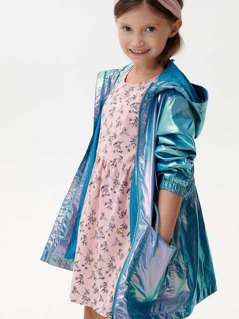 Young girl wearing a blue hooded jacket over a floral dress on a white background