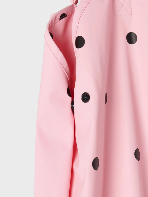 Close-up of a pink raincoat with black polka dots on a light gray background