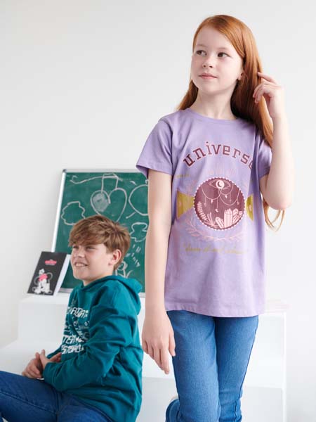 Two children wearing clothing with graphic designs on a white background