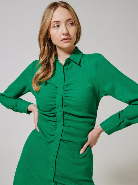 Woman wearing a green dress against a plain background
