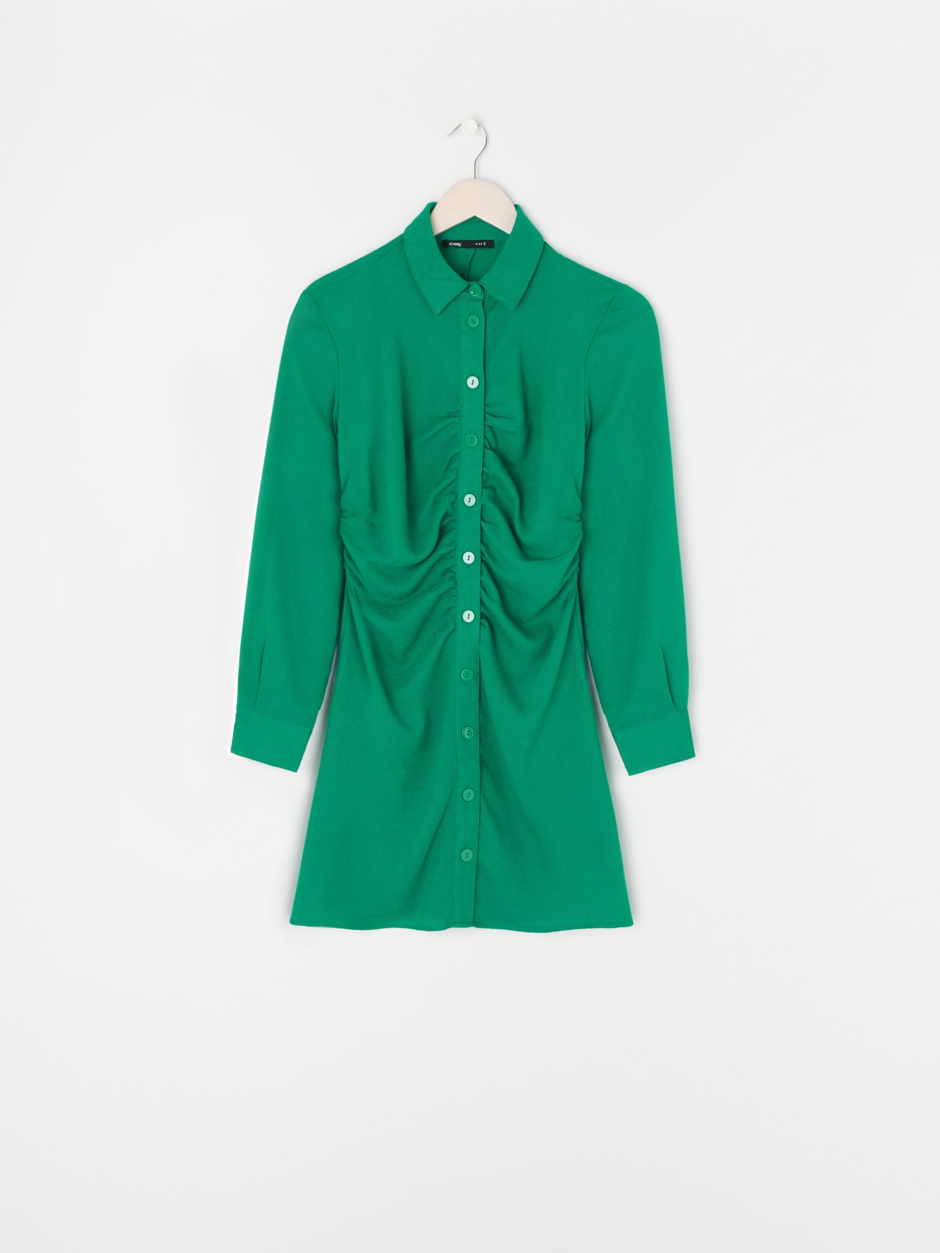 Green dress on a hanger against a white background