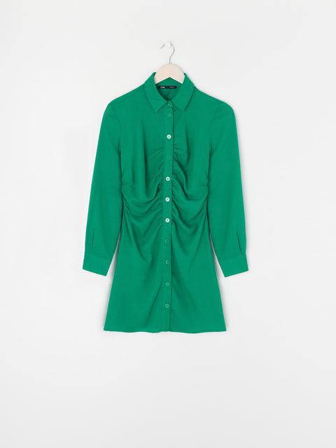 Green dress on a hanger against a white background