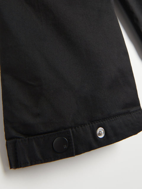 Close-up of a black jacket with buttons on a white background