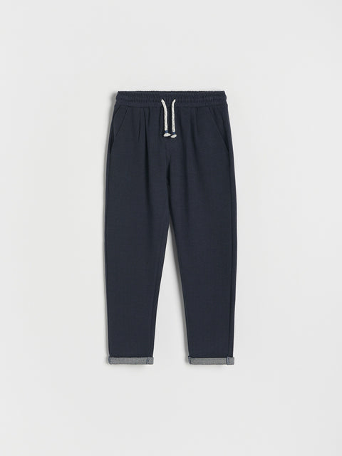 Dark gray jogger pants with a drawstring on a light gray background