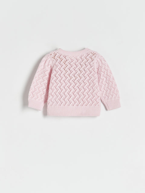 Pink knitted sweater on a light gray background