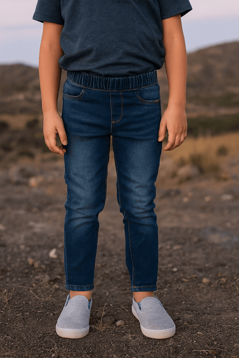 Person wearing a navy shirt and blue jeans standing in a desert landscape.