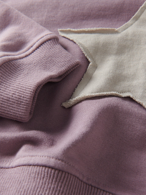 Close-up of a purple garment with a star-shaped cutout detail.