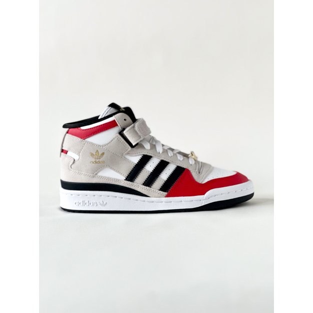 Adidas sneaker with red, white, and black design on a light gray background