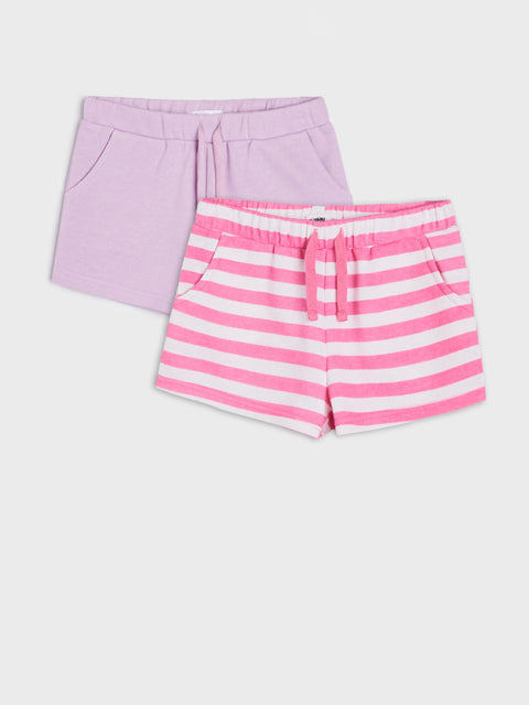 Two pairs of shorts, one lavender and one pink with white stripes, on a light gray background.