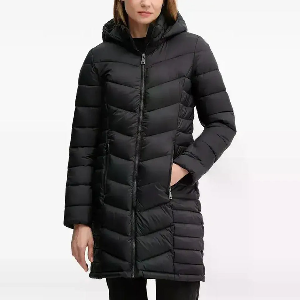 A woman wearing a black hooded puffer jacket with horizontal quilting, shown from the chin down against a plain white studio background.