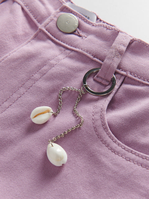 Pink pants with a shell charm hanging from a button