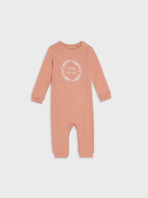 Pink baby onesie with a white floral design and text on a light gray background