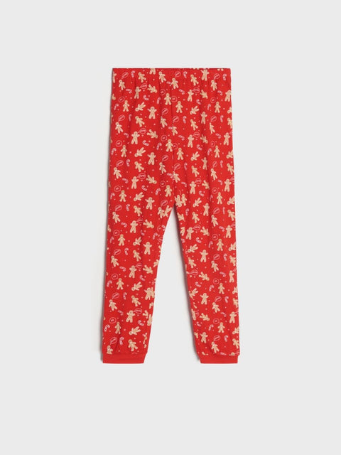 Red leggings with white gingerbread man pattern on a white background