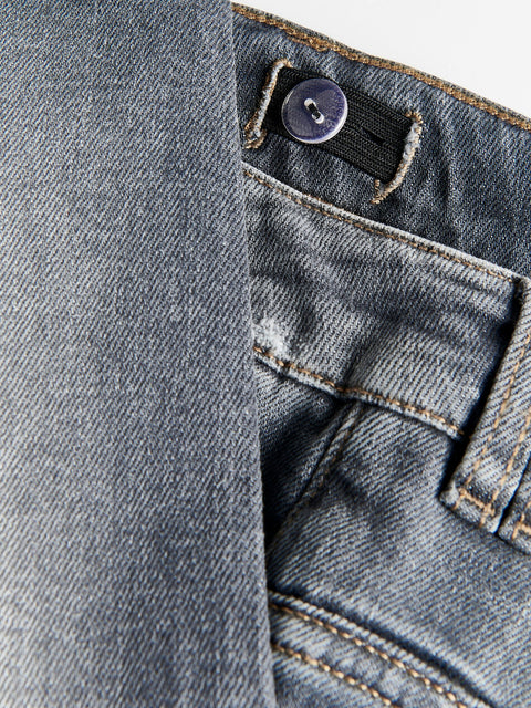 Close-up of a button on a pair of blue jeans.