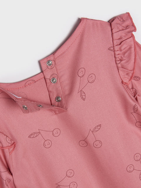 Pink sleeveless top with cherry pattern on a light gray background