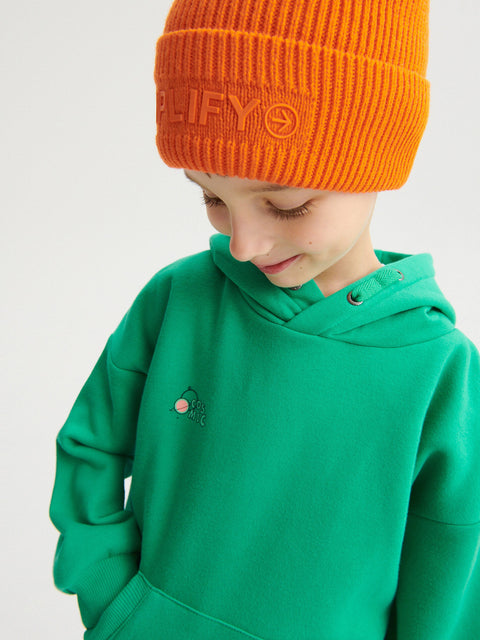 Child wearing a green hoodie and orange beanie with a brand logo on a white background
