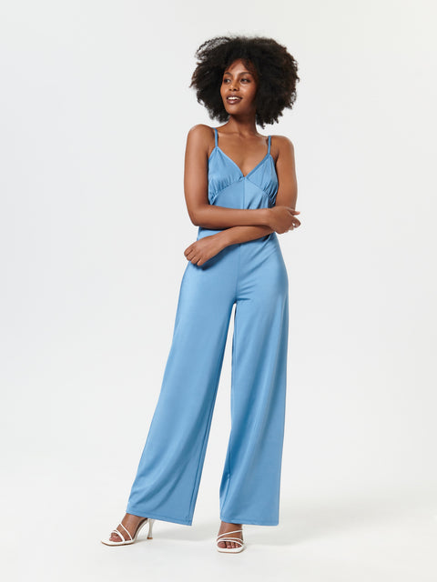 Woman wearing a blue jumpsuit on a white background