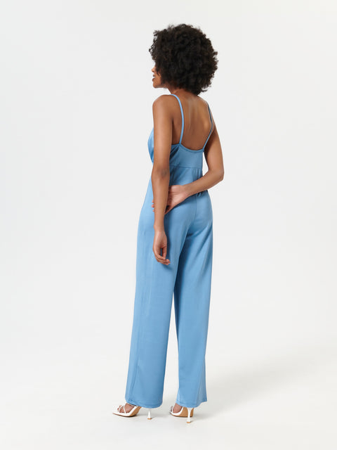 Woman wearing a blue jumpsuit on a white background