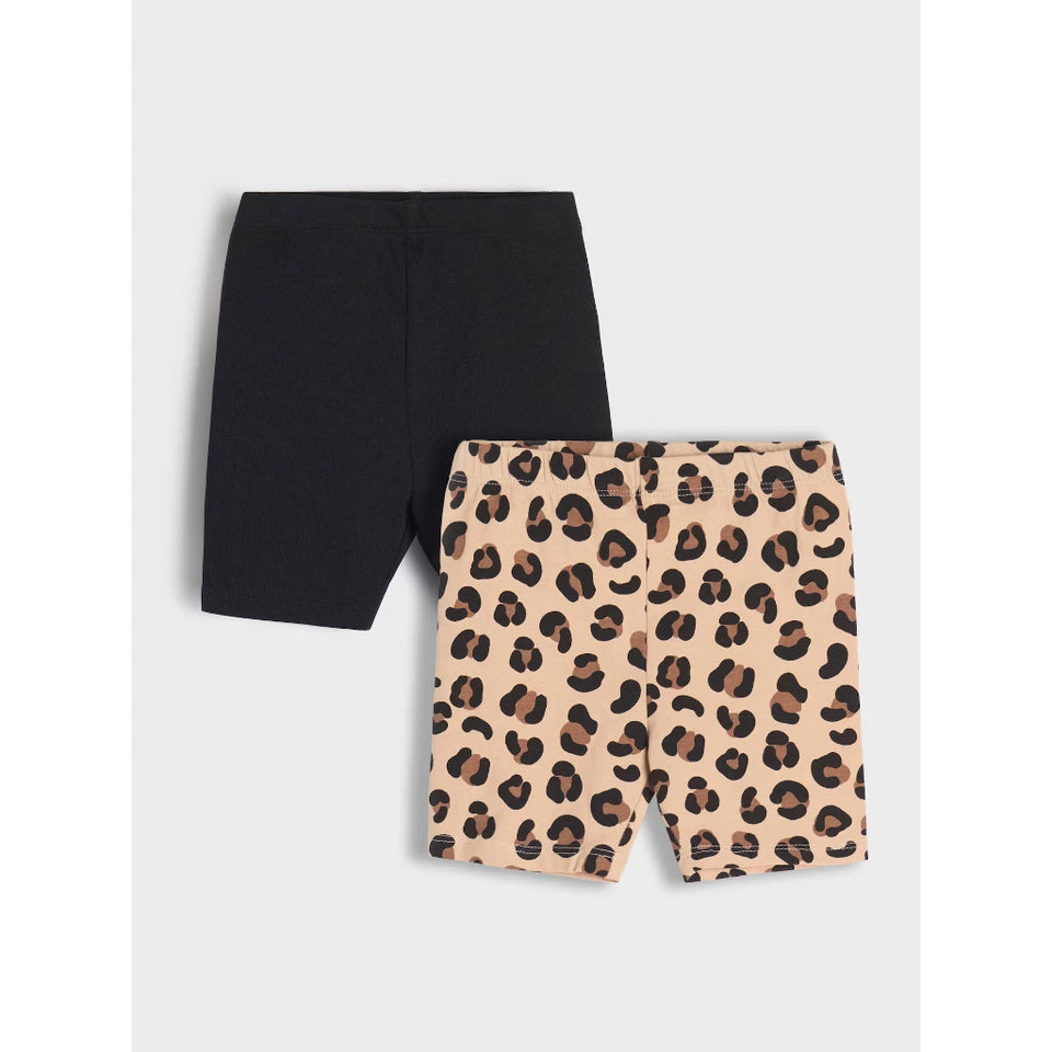 Two pairs of children's biker shorts laid flat on a light gray background: one solid black pair and one beige leopard-print pair with dark brown and black spots.