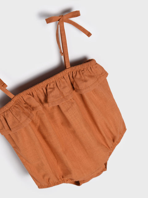Brown baby romper with tie straps on a white background