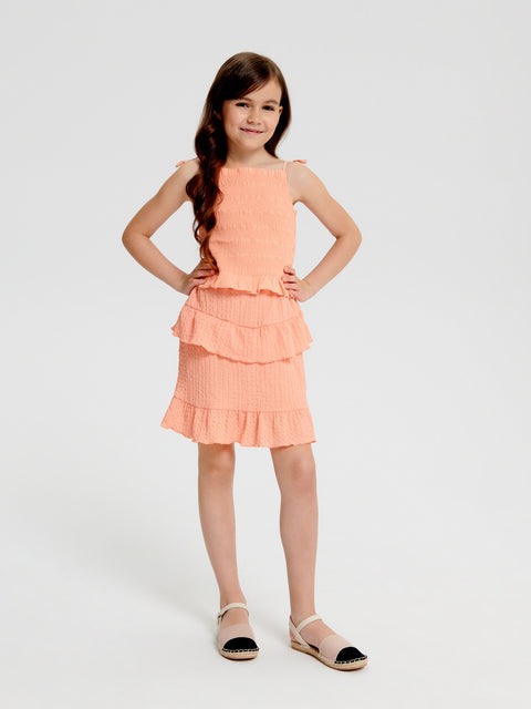Young girl wearing a peach dress on a white background