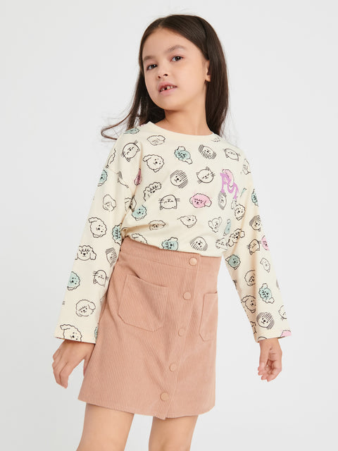 Young girl wearing a patterned shirt and pink skirt on a white background