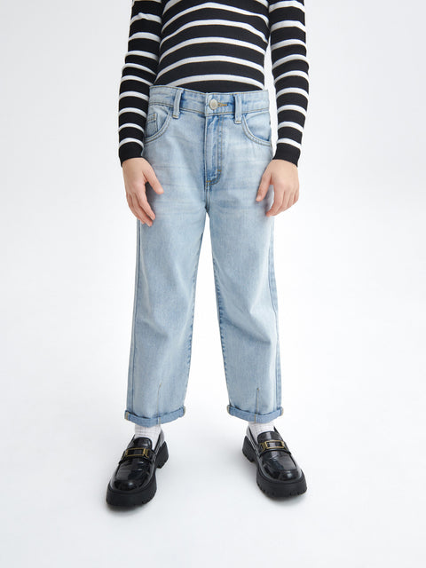 Person wearing a black and white striped shirt, light blue jeans, and black shoes on a white background