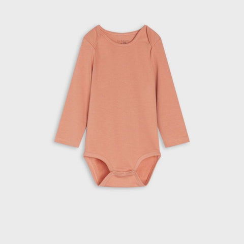 Pink bodysuit with long sleeves on a light beige background