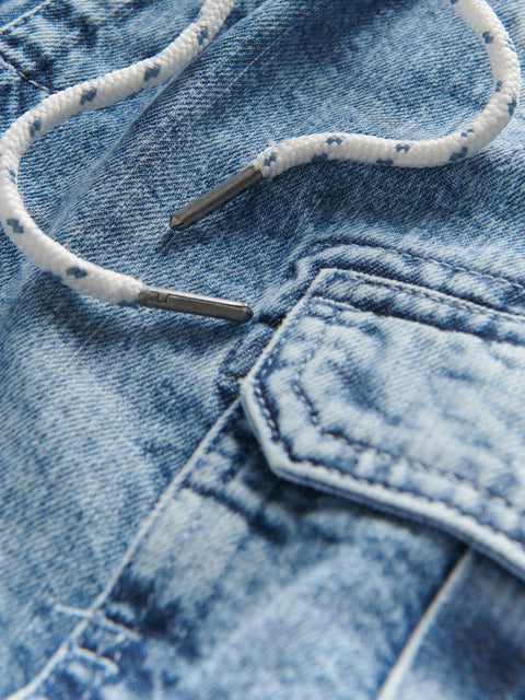 Close-up of blue denim fabric with a pocket and white shoelace.