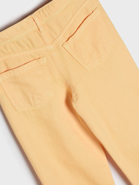 Close-up of peach-colored pants on a white background