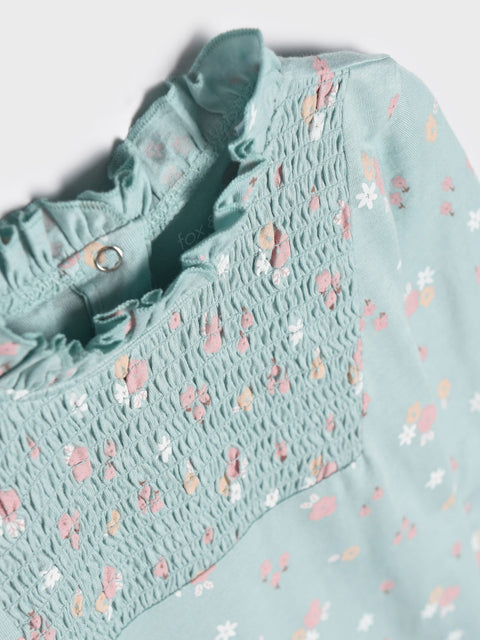 Light blue blouse with floral pattern on a white background