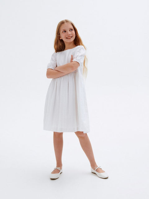 Young girl wearing a white dress on a white background